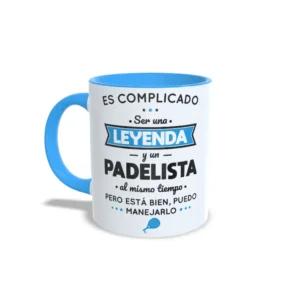 Taza de cerámica sobre pádel con frase es complicado ser una leyenda y un padelista al mismo tiempo, interior y asa en color azul claro, vista lateral izquierda.