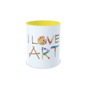 Taza de cerámica sobre pintura y arte con frase I love art formada por materiales de dibujo como pinceles, paleta y lápices, interior en color amarillo, vista frontal centrada.