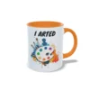 Taza de cerámica sobre pintura y arte con frase I arted, paleta de colores con pinceles y salpicaduras multicolor, interior y asa en color naranja, vista lateral derechha.