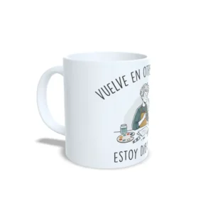 Taza de pintura y dibujo con ilustración de hombre dibujando frente a su caballete y frase Vuelve en otro momento, estoy dibujando, interior y asa en color blanco, vista lateral izquierda.
